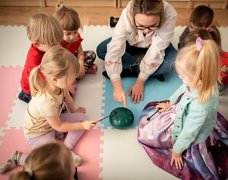 zp1 zdjęcie przedstawia opiekunkę i dzieci podczas zajęć